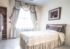 a bedroom with a bed and a large window at Batavia Apartment ST in Jakarta