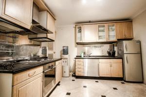 a kitchen with wooden cabinets and a refrigerator at Batavia Apartment ST in Jakarta