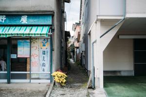 un vicolo con fiori di fronte a un edificio di CASA DE YOSHi 一棟貸し a Yamagata