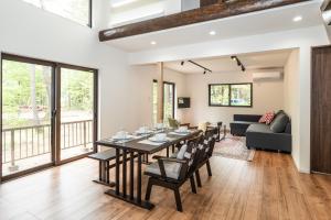 a dining room and living room with a table and chairs at Ringo Cottage in Hakuba