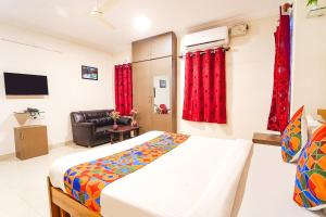 a bedroom with a bed and a chair in it at FabExpress Mann Pasand Inn in Bangalore