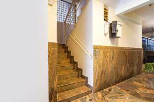 a staircase in a building with wooden floors at FabExpress Mann Pasand Inn in Bangalore