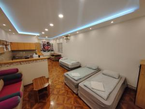 a living room with two beds and a kitchen at MAGENTA Apartments in Belgrade