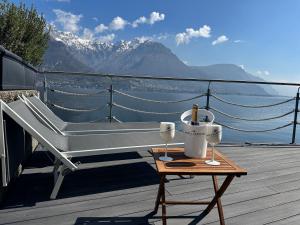 una panchina su un ponte con un tavolo con bicchieri da vino di Al Molo 5 - Lake Front a Oliveto Lario