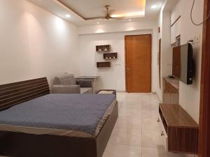 a bedroom with a bed and a desk and a television at North Eye Studio in Noida