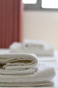 a stack of white towels sitting on a table at Garden Rooms in Himare +107 photos