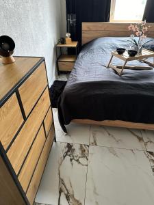 Schlafzimmer mit einem Bett und einem Tisch auf einem Marmorboden in der Unterkunft Mieszkanie przy morzu in Danzig