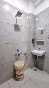 a bathroom with a toilet and a sink at Staeg Mercury 1BHK -103 in Indore