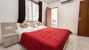 a bedroom with a red bed with a window at Staeg Mercury 1BHK -103 in Indore +10 photos