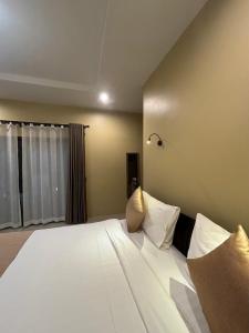 sypialnia z dużym łóżkiem z białą pościelą i poduszkami w obiekcie Serene Lanta Resort w mieście Ko Lanta