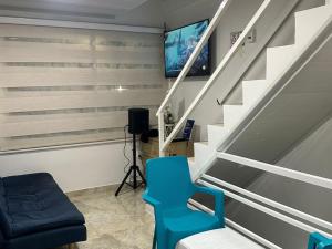 Apartamentos Mar & Arena في سان أندريس: غرفة معيشة مع كرسي أزرق وتلفزيون