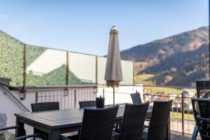 a table and chairs on a balcony with an umbrella at Haus Wieser in Kaprun