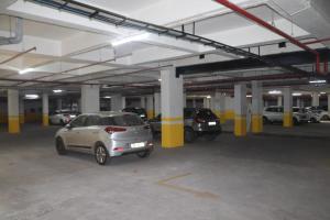 a parking garage with several cars parked in it at Hotel Gold Palace Inn in Surat