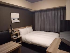 Postel nebo postele na pokoji v ubytování Hotel Route-Inn Yamanashi Chuo