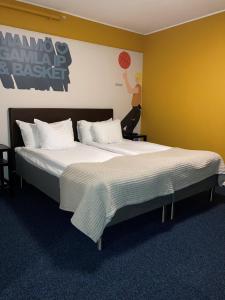 1 dormitorio con 2 camas y un cartel de baloncesto en la pared en HOTEL N Hostel Malmö City en Malmö