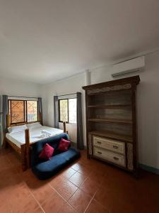 a bedroom with a large bed and a blue couch at VitaminSea Room in Dauin