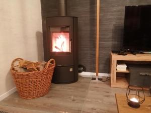 a living room with a heater and a basket at Fewo River I Familienfreundlich I großer Garten I inkl Badefass I Kamin I Spielplatz in Wendisch Rietz