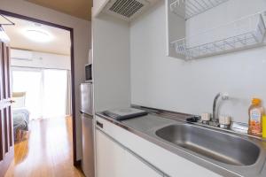 a kitchen with a sink and a refrigerator at Grande es TENJIN in Fukuoka
