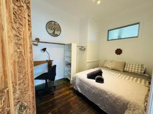 a bedroom with a bed and a desk and a window at Brunswick Riverfront Apartment - Absolute Riverfront in Brunswick Heads