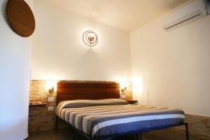una camera con letto e testiera in legno di Affittacamere Soleluna a Castiadas