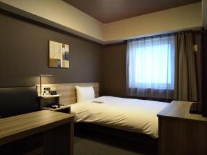 Postel nebo postele na pokoji v ubytování Hotel Route-Inn Mihara Ekimae