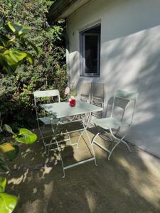 una mesa y dos sillas sentadas junto a un edificio en Maisonnette dans jardin partagé, en Colombes