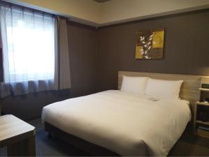 Postel nebo postele na pokoji v ubytování Hotel Route-Inn Mihara Ekimae