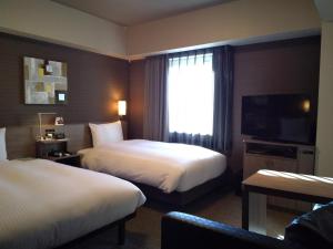 Postel nebo postele na pokoji v ubytování Hotel Route-Inn Mihara Ekimae
