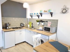 a kitchen with a sink and a microwave at Petrosani Central ApartHotel in Petroşani