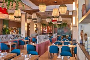 Riu Turquoise - All Inclusive في لو مورن: غرفة طعام مع طاولات وكراسي زرقاء