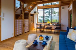 スイートヴィラ オーシャンビュー熱海⾃然郷 في أتامي: غرفة معيشة مع أريكة زرقاء وطاولة