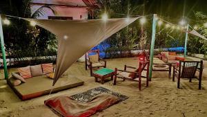 een groep stoelen en een tent op een strand bij Zen Boutique Resort in Jambiani