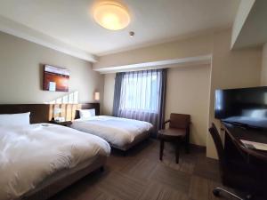 una habitación de hotel con 2 camas y un piano en Hotel Route-Inn Miyazaki Tachibana Dori en Miyazaki