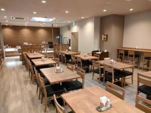 宮崎的住宿－Hotel Route-Inn Miyazaki Tachibana Dori，一间空餐厅,配有木桌和椅子