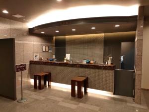 baño con encimera con bancos y espejo en Hotel Route-Inn Miyazaki Tachibana Dori en Miyazaki