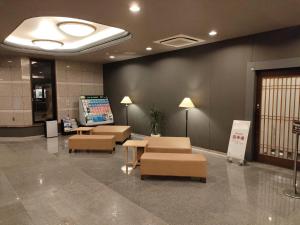 a waiting room with couches and tables in a building at Hotel Route-Inn Miyazaki Tachibana Dori in Miyazaki