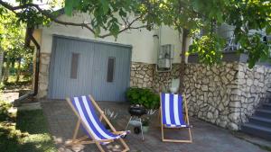 two chairs sitting on a patio in front of a house at Madarász 7 Deluxe Vendégház in Balatonalmádi