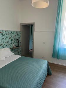 a bedroom with a bed with a blue comforter at B&B Corso Italia 58 in Orbetello