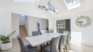 a dining room with a white table and chairs at Tallowwood in Pokolbin