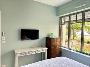 a bedroom with a bed and a tv and a window at Face Mer Villa Le Ker Breton in Pornichet