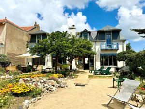 a house with a yard with chairs and flowers at Face Mer Villa Le Ker Breton in Pornichet