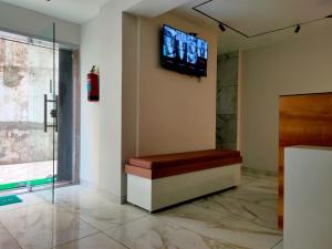 a waiting room with a tv on a wall at HOTEL JANTA INn in Vapi