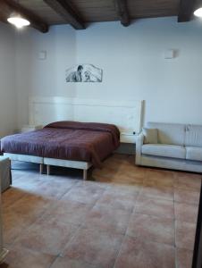 ein Schlafzimmer mit einem Bett und einem Sofa darin in der Unterkunft L'Arco Antico in Casalbuono