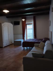 ein Wohnzimmer mit einem Sofa und einem Bett in der Unterkunft L'Arco Antico in Casalbuono