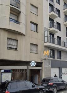 Dos coches aparcados delante de un edificio en Appartement au Pied du Metro Mairie de Clichy L13, en Clichy