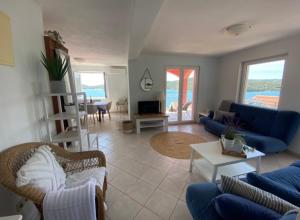 a living room with blue couches and a table at SEASPRAY APARTMENTS TISNO in Tisno