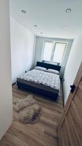 a bedroom with a bed and a rug on the floor at Apartament Daszyńskiego in Sanok