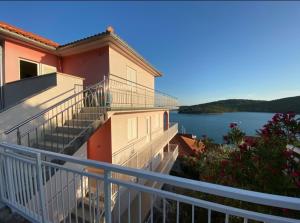 a balcony of a building with a view of a lake at SEASPRAY APARTMENTS TISNO in Tisno