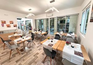 un restaurante con mesas y sillas en una habitación en chiAma Hotel en Rímini