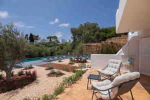 un patio con 2 sedie e una piscina di MarSenses Natura Olea Hotel a Cala d´Or